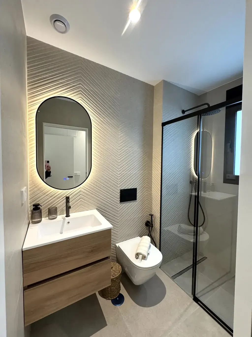 Salle d'eau moderne équipée d'une douche à l'italienne et d'un meuble vasque suspendu