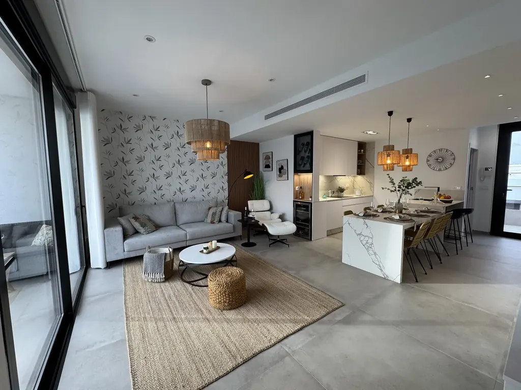 Séjour et salle à manger lumineux d'un appartement neuf, ouverts sur une cuisine contemporaine
