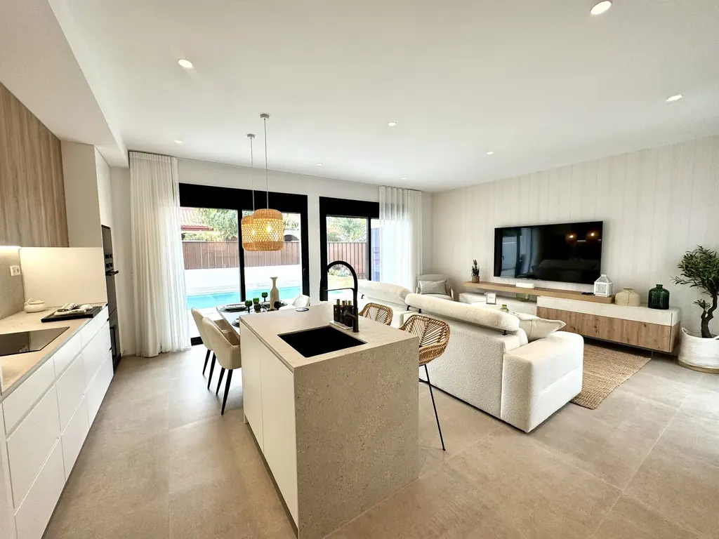 Grand espace de vie d'une villa neuve ouvert par des baies vitrées sur la piscine et la terrasse